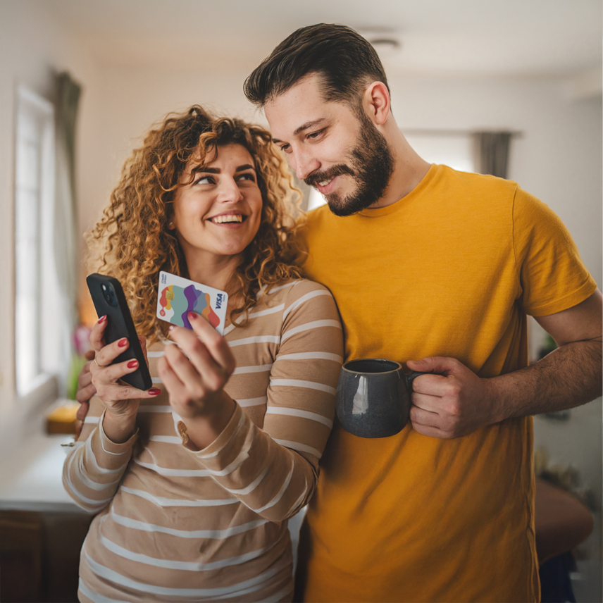 Credit Union Current Account - Couple holding mobile phone and Visa Debit Card